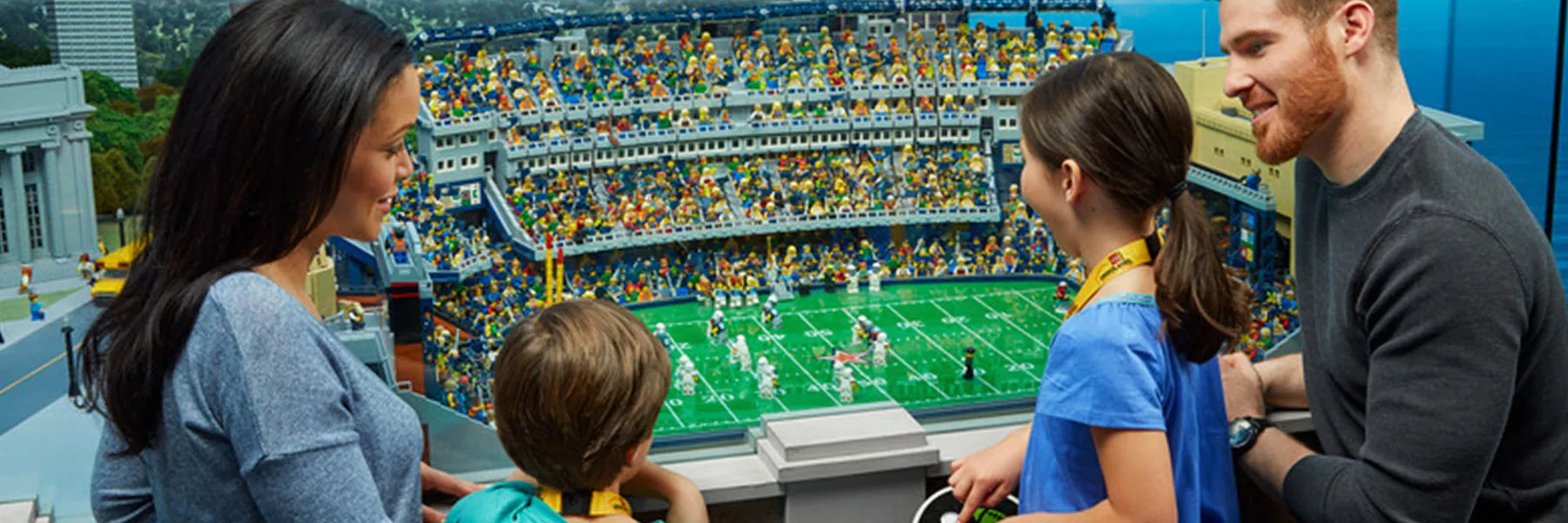 A family examining the LEGO stadium in MINILAND at LEGOLAND Discovery Center New Jersey.